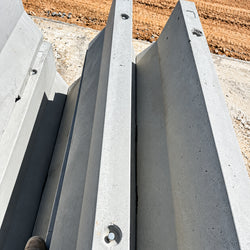 Heavy-duty 1800kg 30MPa concrete Jersey kerb barrier with 600mm wide base, 150mm top, and bottom drainage slots for roadworks and site protection.