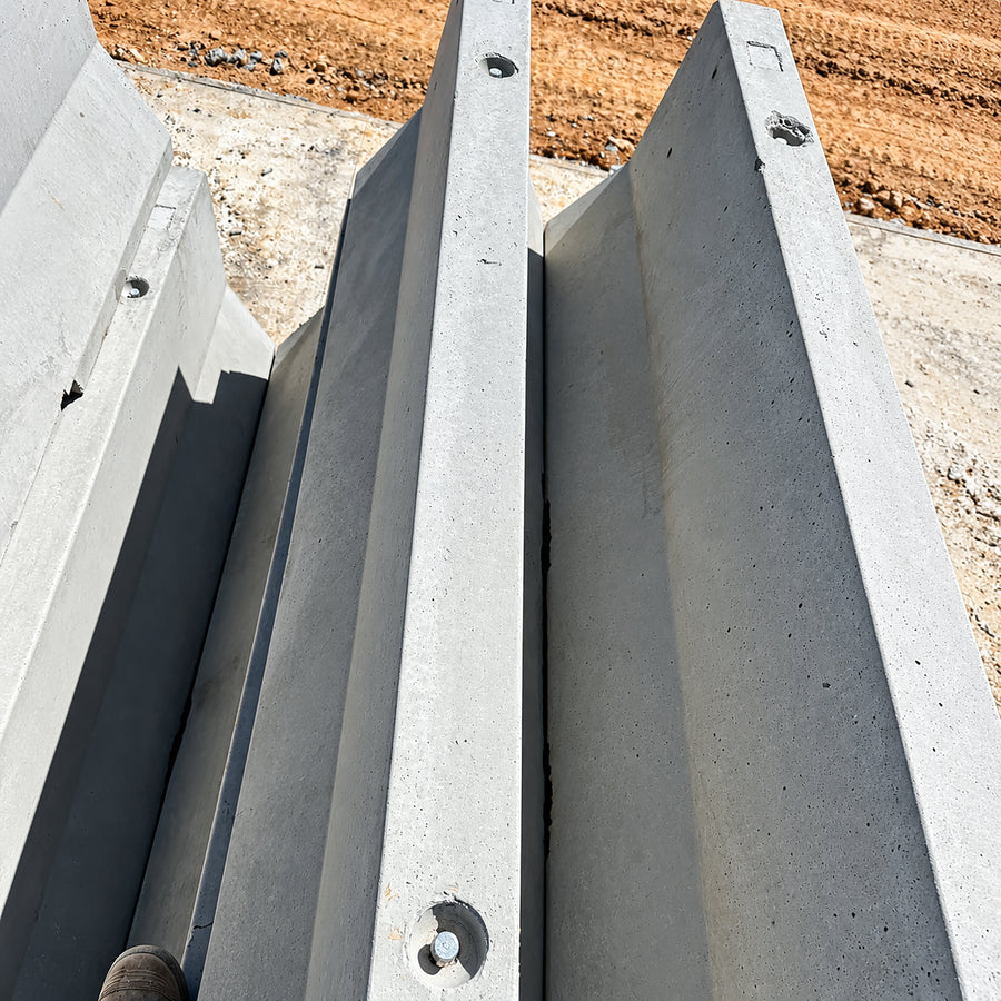 Heavy-duty 1800kg 30MPa concrete Jersey kerb barrier with 600mm wide base, 150mm top, and bottom drainage slots for roadworks and site protection.