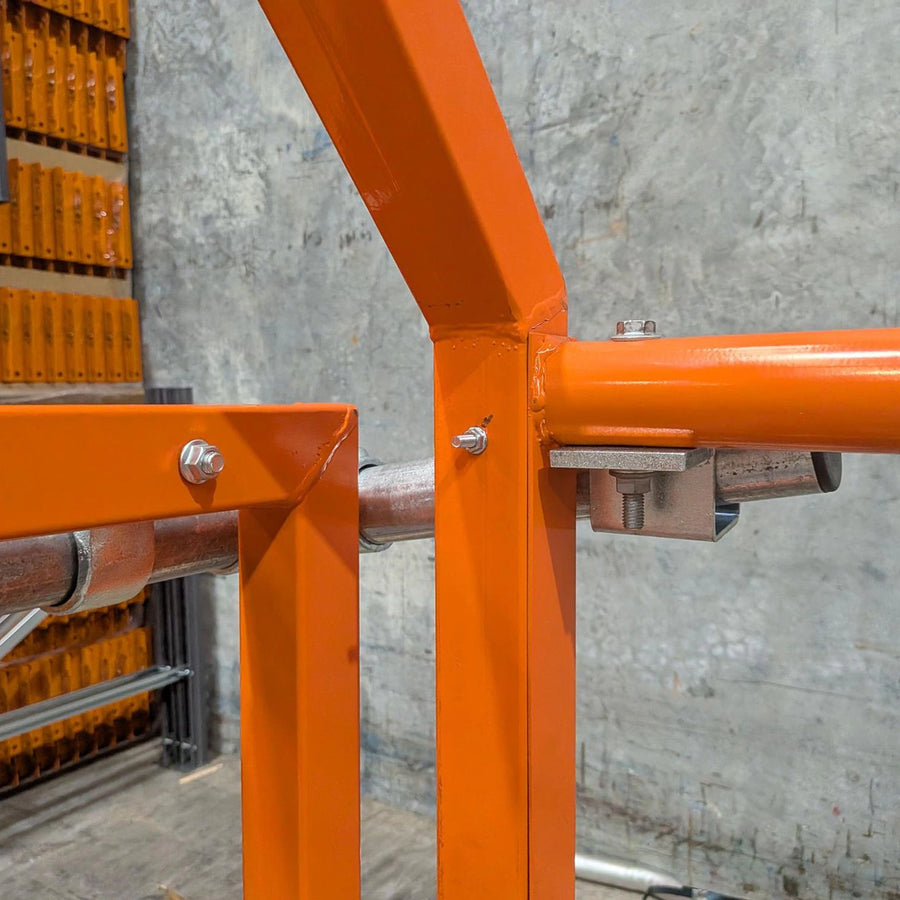 Powdercoated orange mezzanine up and over pallet transfer safety gate.