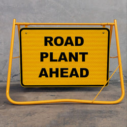 Flat-folding yellow swing stand sign frame for easy transport in construction utes and trucks, featuring a removable metal sign face for site versatility.