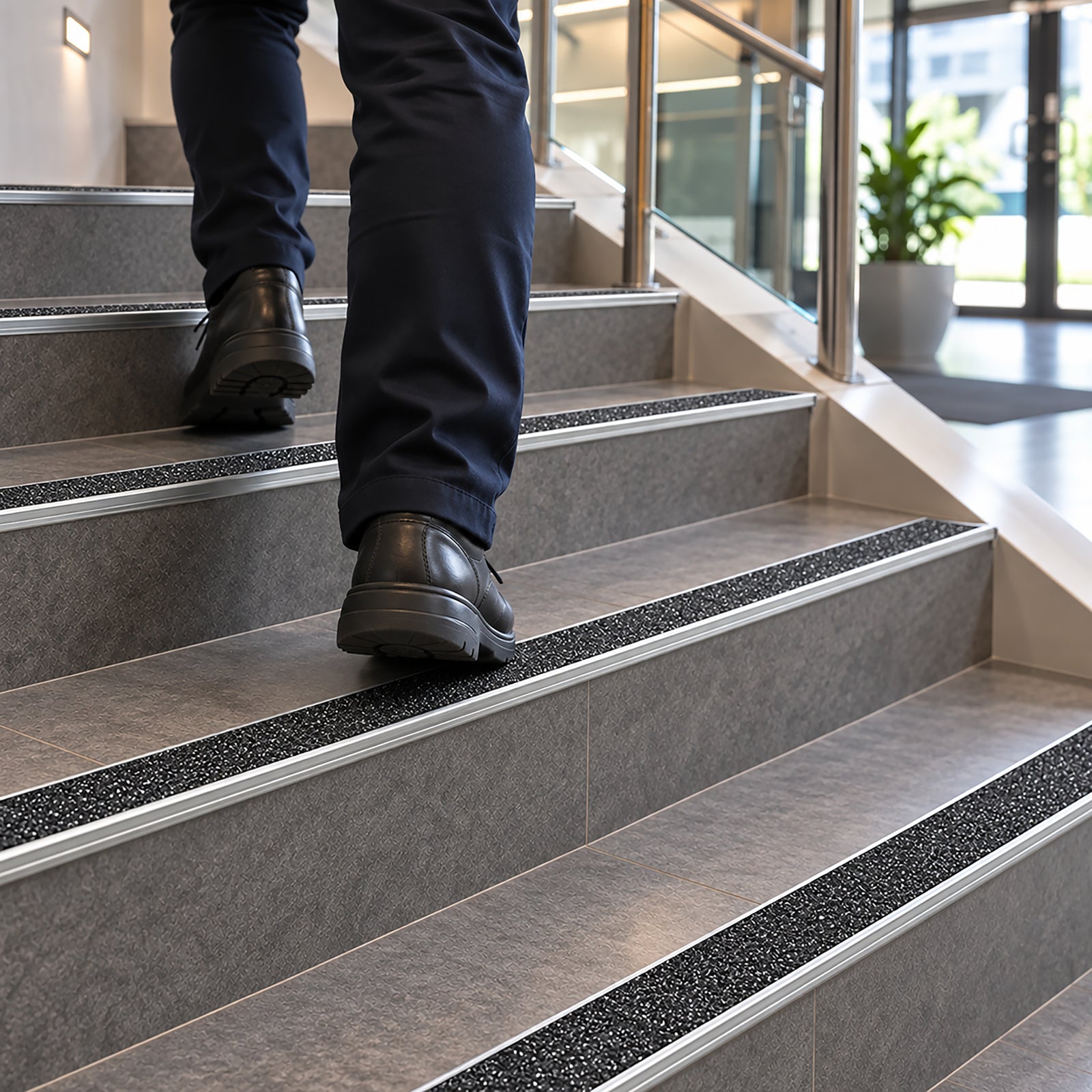 Single-piece low-profile aluminium stair nosing featuring a safety yellow carborundum grip strip for P5 slip resistance.