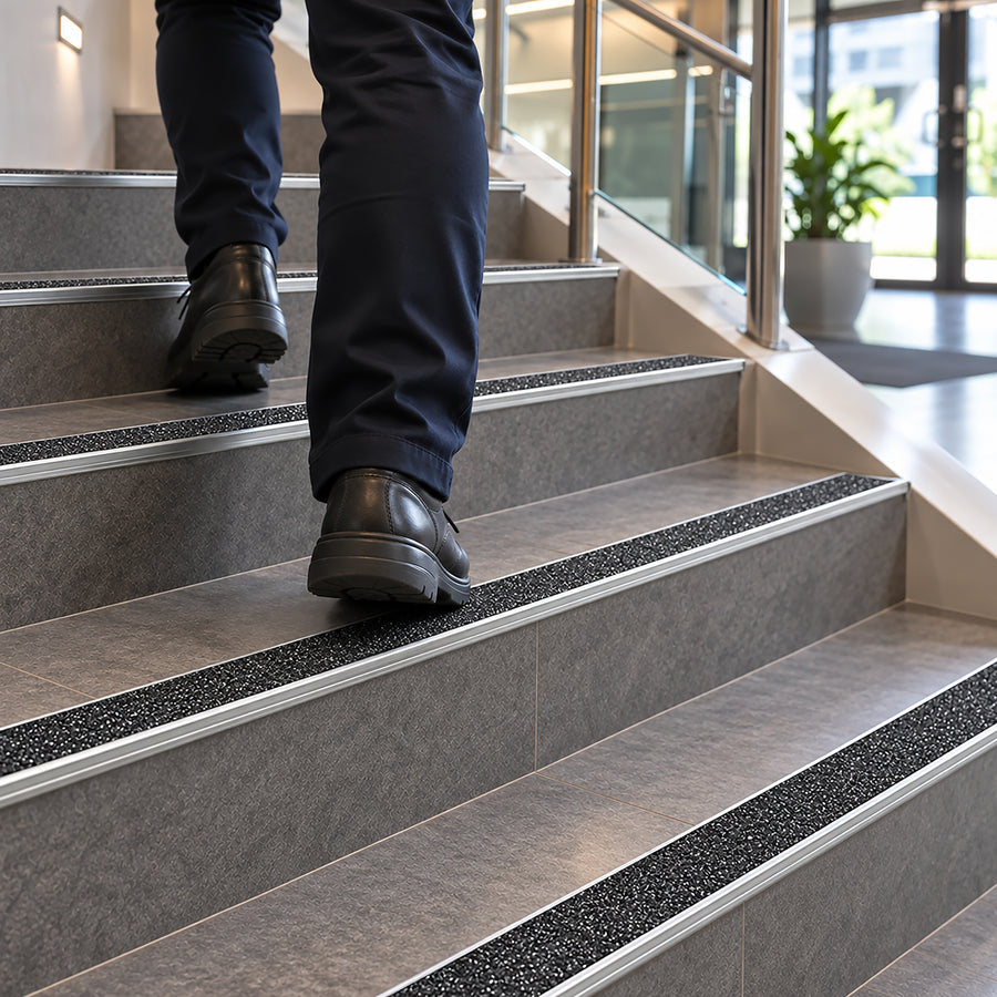 Single-piece low-profile aluminium stair nosing featuring a safety yellow carborundum grip strip for P5 slip resistance.