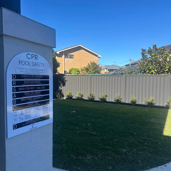 CPR pool safety sign beside fenced backyard pool area in Australia